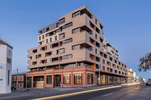 A multi-story building with a modern architectural design, featuring balconies and large windows. - Fitzroyals Uchi in Melbournes Multicultural Hub (Fitzroy)