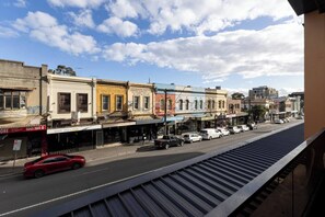 A street view with buildings, a red car, and a clear sky. - Fitzroyals Uchi in Melbournes Multicultural Hub (Fitzroy)