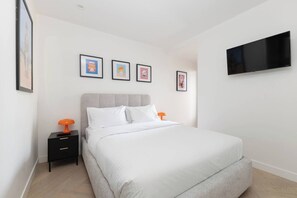 A bedroom with a bed, nightstands, a TV, and framed pictures on the wall. - Fitzroyals Uchi in Melbournes Multicultural Hub (Fitzroy)