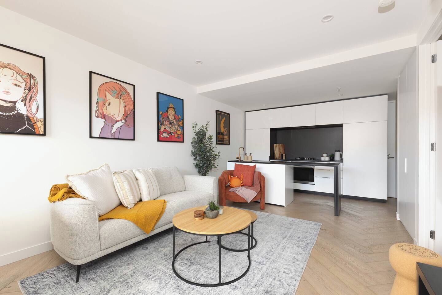 A modern living room with a sofa, coffee table, and artwork on the wall.