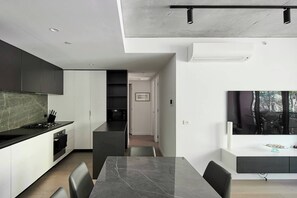 Une cuisine moderne avec un plan de travail en marbre, une table à manger et des chaises.