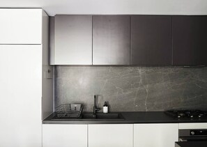 Eine moderne Küche mit Marmorfliesenspiegel, Edelstahlgeräten und einem minimalistischen Design.