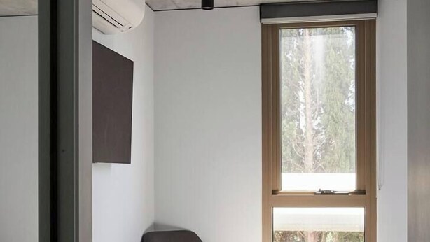 A bedroom with a single bed, a chair, and a large window. - Modern Minimalism Slate Chic in the City (North Melbourne)
