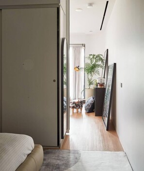 A modern bedroom with a bed, a door leading to a balcony, and a view of the outdoors. - Urban Artistry Loft A Haven Above the Bustle (Melbourne)