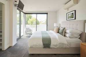 A bedroom with a bed, a chair, a TV, and a window. - Swanston Sands Sophisticated Comfort by the Beach (Geelong)
