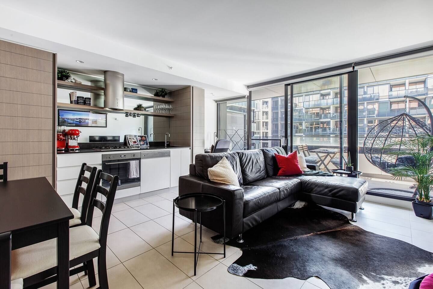 Un appartement moderne comprenant une cuisine, un coin repas et un salon avec une grande fenêtre.