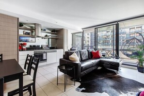 Eine moderne Wohnung mit Küche, Essbereich und Wohnzimmer mit großem Fenster.