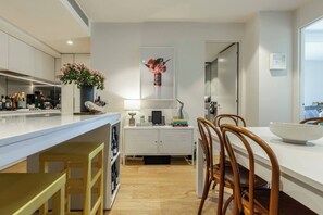 Eine moderne Küche mit Bar, Holzstühlen und einem Esstisch.