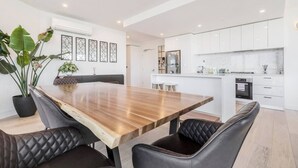 A modern kitchen with white cabinets, a stainless steel refrigerator, and a built-in oven. - The Fawn Relish in Sub Penthouse Panorama (North Melbourne)
