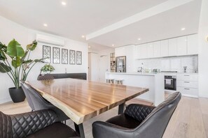 Eine moderne Küche mit weißen Schränken, einem Edelstahl-Kühlschrank und einem eingebauten Backofen.