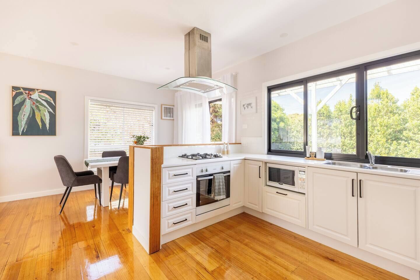 The bright kitchen invites relaxed cooking with its gas cooktop, oven, dishwasher, microwave, Nespresso machine, and all the essentials for effortless meals at home.