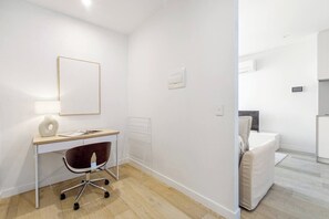 Une chambre moderne et minimaliste, équipée d’un bureau, d’une chaise et d’un lit.
