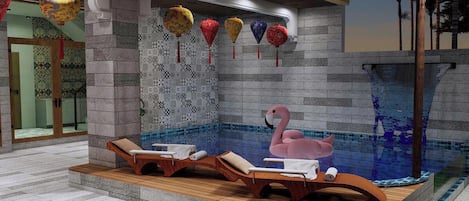 A spa area with a hot tub, lounge chairs, and decorative lanterns.