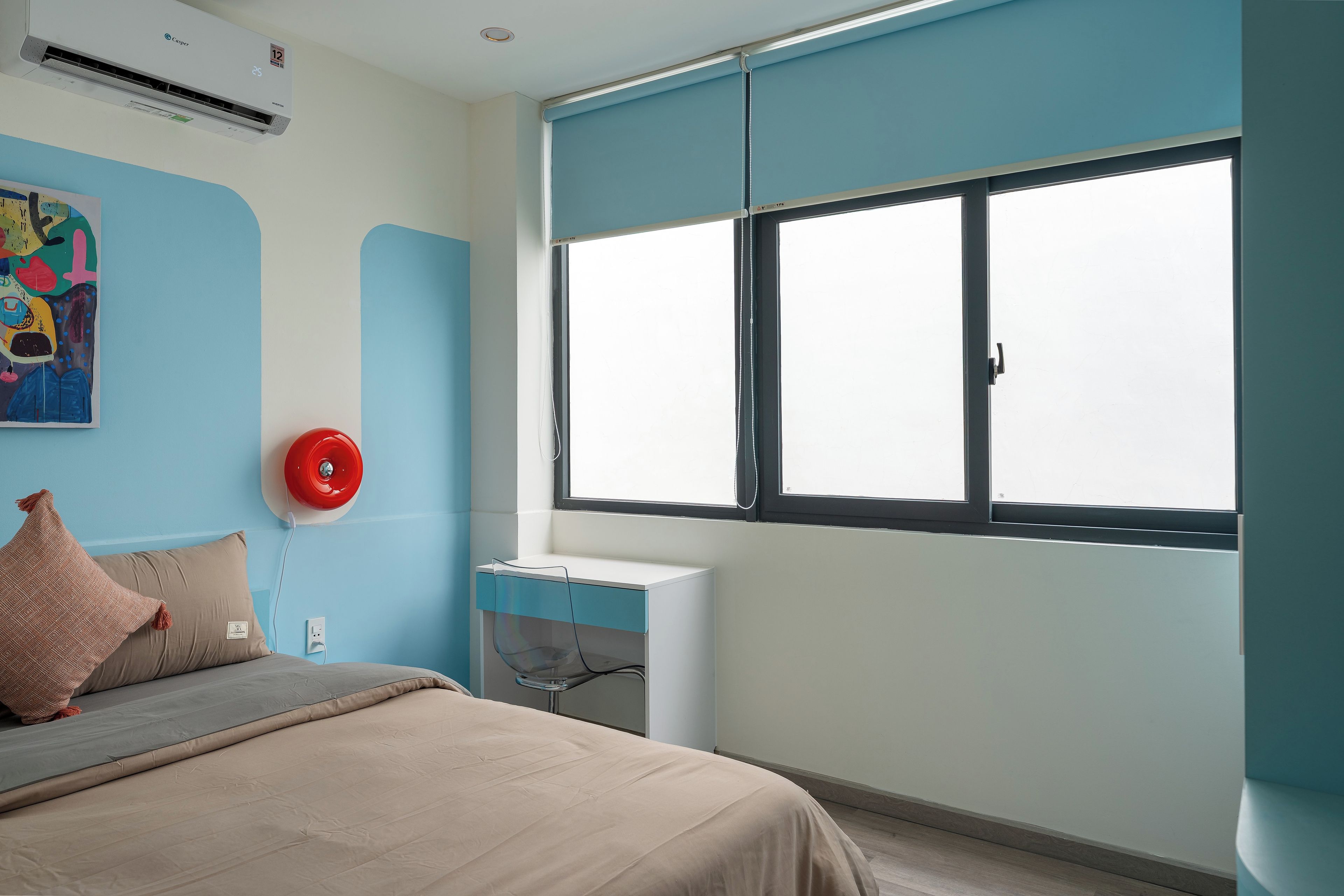 Un dormitorio con cama, escritorio, ventana y aire acondicionado instalado en la pared.