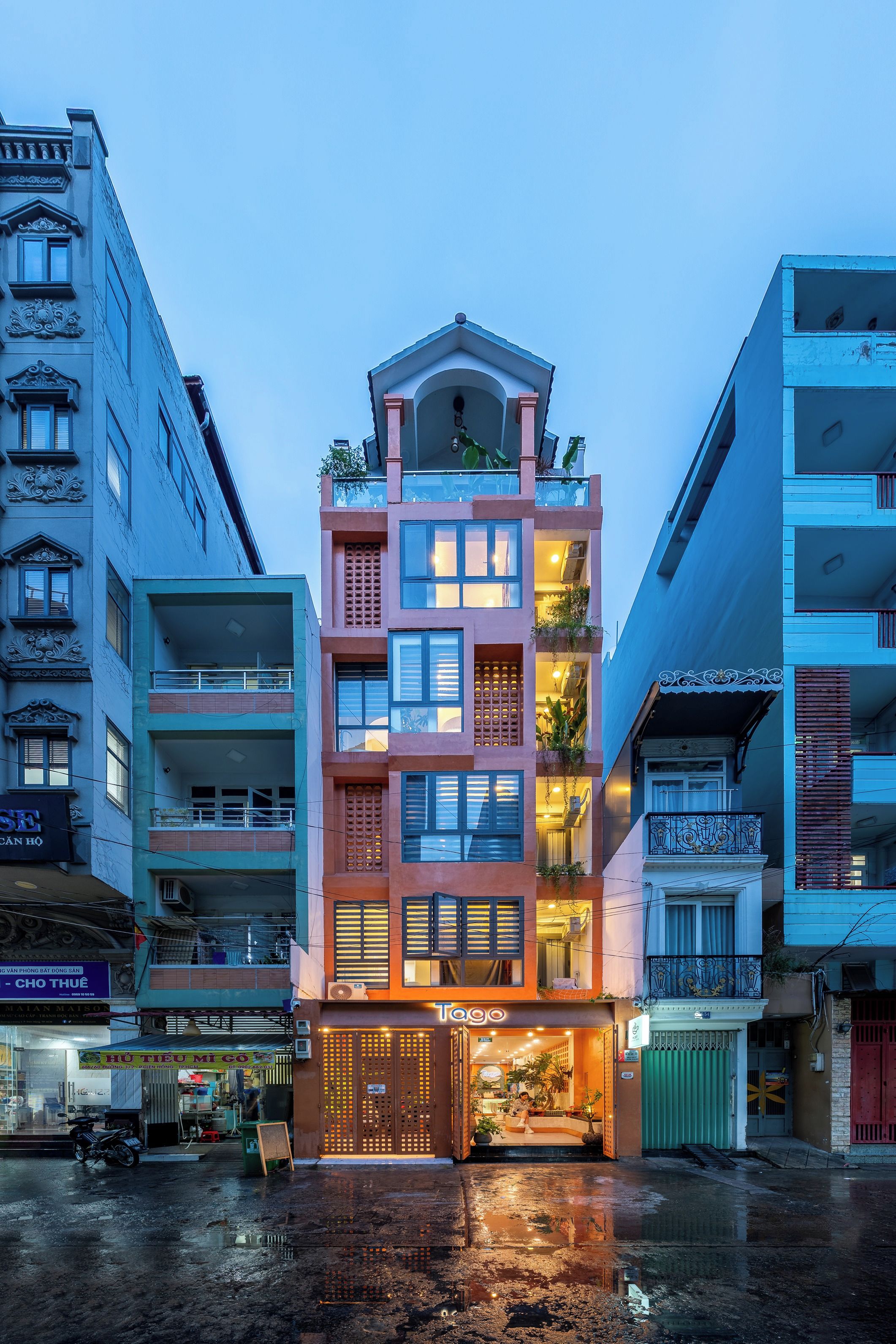 A multi-story building with a ground-level entrance, balconies, and a mix of architectural styles.