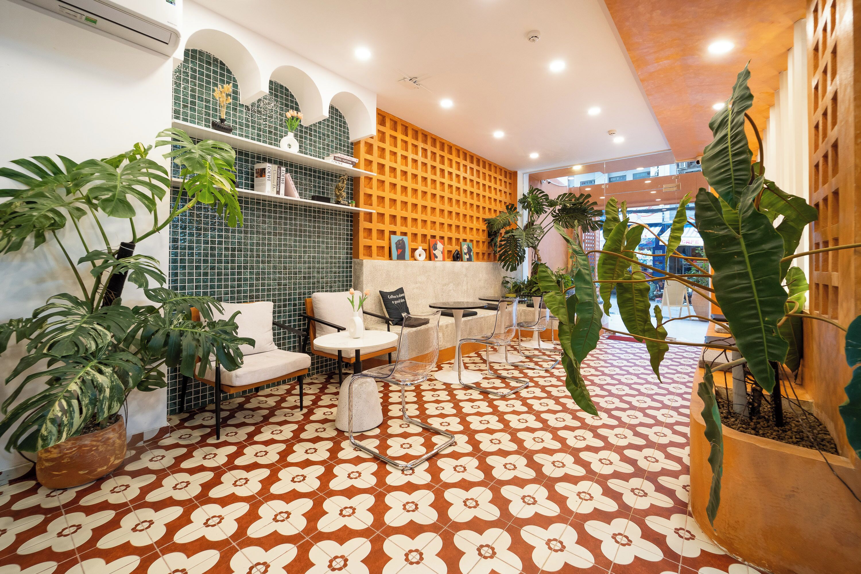 Un intérieur moderne avec un sol à motifs, un espace salon et diverses plantes.