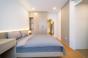 Un dormitorio moderno con cama, mesitas de noche y armario.
