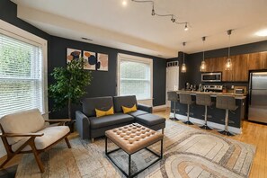 Living room — sectional, accent chair, and breakfast-bar seating for four - King 1BR Opposite SLU Hospital Balcony  Parking (St. Louis)