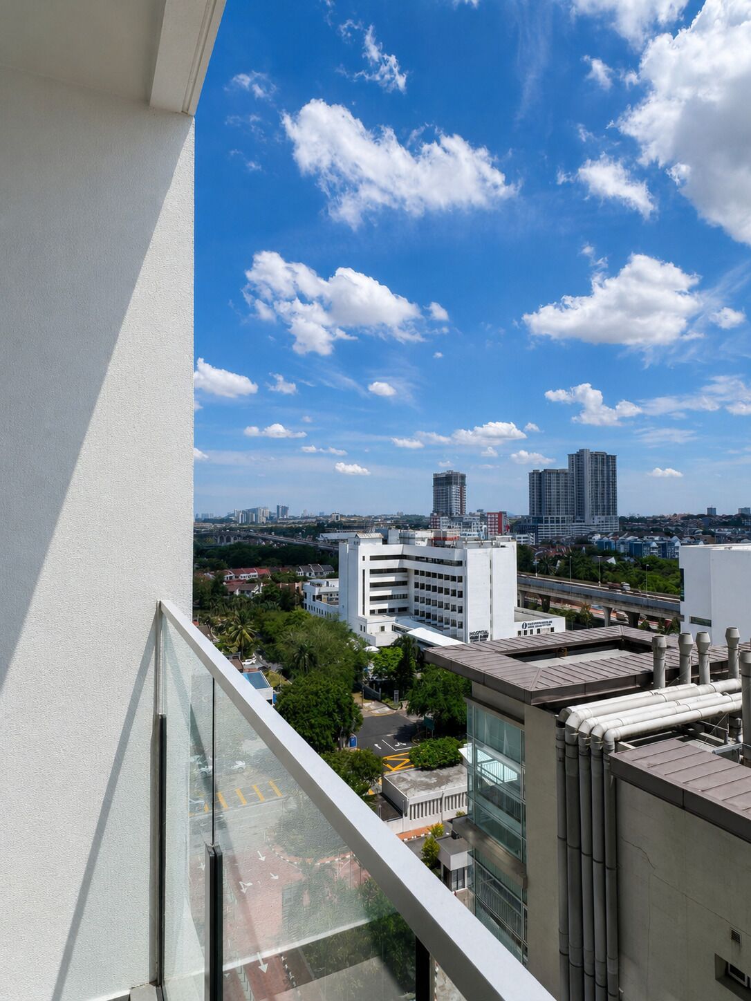 A high-rise building with a clear view of the cityscape, including other buildings and a bridge in the distance.