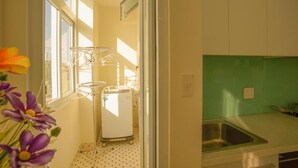 Una cocina con un lavamanos, refrigerador y ventana con vistas.