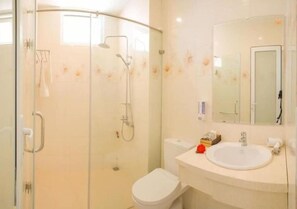 A bathroom with a glass shower enclosure, a white toilet, and a sink with a mirror above it. - Green Garden Residence hotel (Ngu Hanh Son)