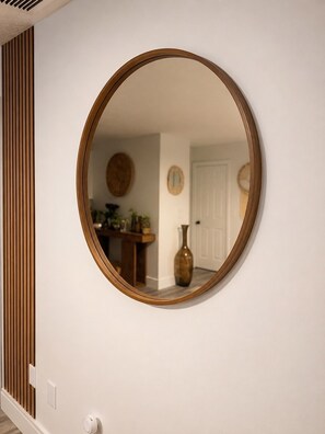 A round mirror with a wooden frame on a white wall. - Palm Vibe House - Pool • Near Beach • Florida (Port St. Lucie)