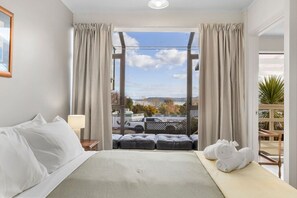 Une chambre d’hôtel avec un lit, une vue sur l’extérieur et un balcon.
