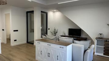 A modern living room with a sofa, a TV, and a wooden cabinet.