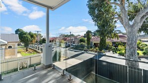 A residential area with houses, a tree, and a clear sky. - Campbelltown modern home Family Stay (Campbelltown)