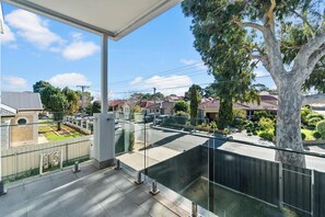 A residential area with houses, a tree, and a clear sky. - Campbelltown modern home Family Stay (Campbelltown)