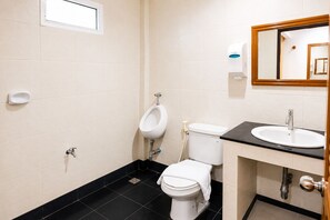 A bathroom with a urinal, toilet, sink, and mirror. - Yindee Court Hotel (Rayong)
