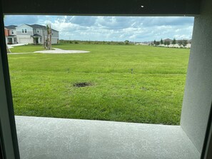 Blick auf eine grüne Rasenfläche mit einem Haus im Hintergrund.