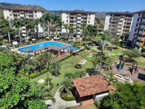 Un hôtel doté d’une piscine, de palmiers et offrant une vue sur le paysage environnant.