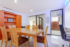 Een vergaderruimte met een houten tafel en stoelen, een whiteboard en uitzicht op een balkon.