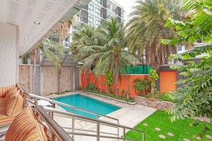 A pool area with a clear view of the pool, surrounded by palm trees and a variety of plants. - Royal Grand - Luxury 4-bedroom villa for 8 people in Pattaya (Bang Lamung)
