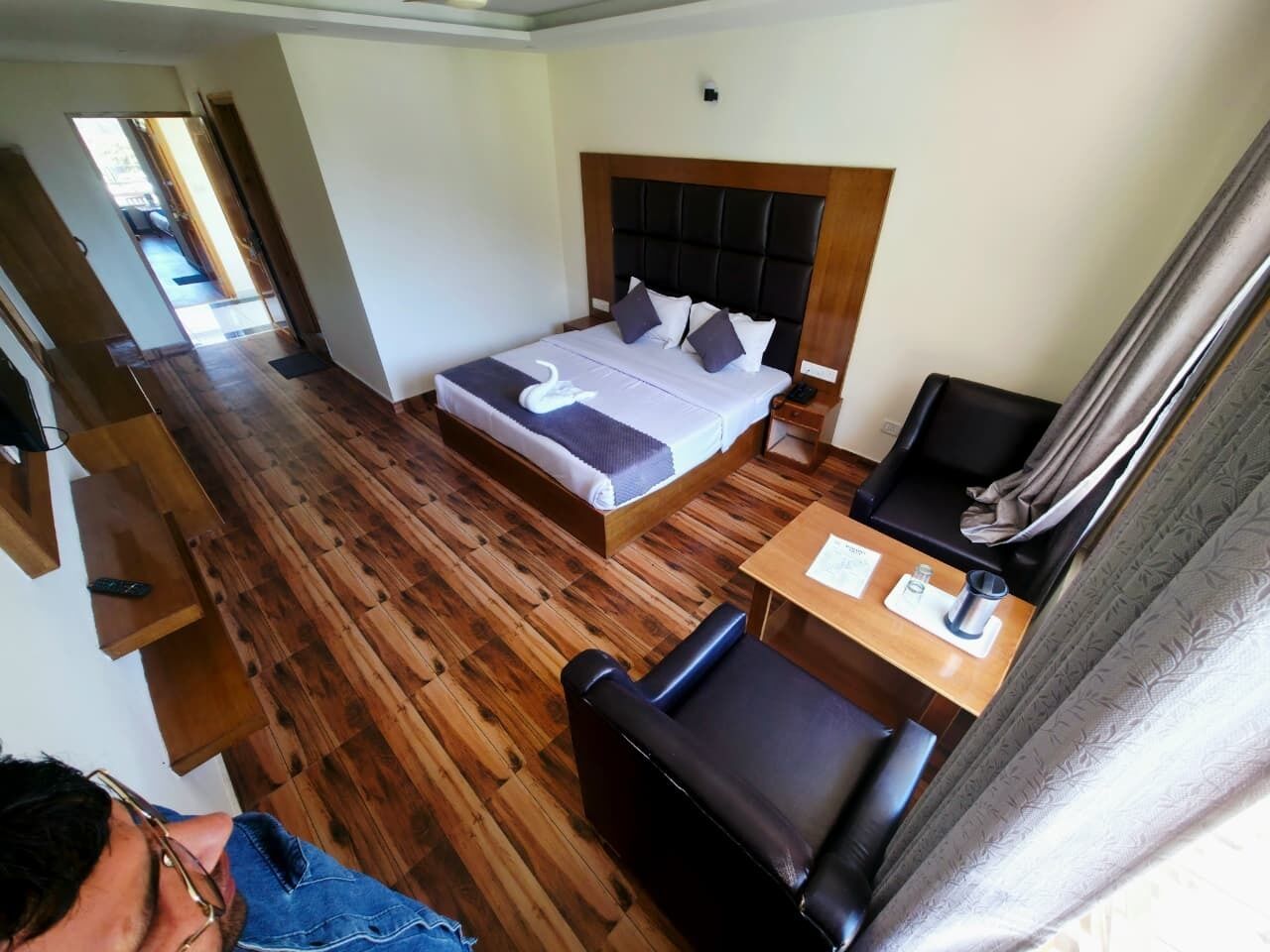 Une chambre d’hôtel avec un lit, un bureau, une chaise et une petite table.