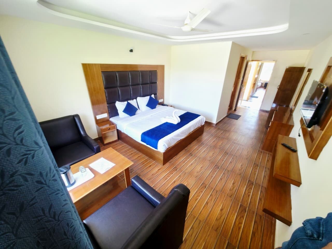 Een hotelkamer met een bed, een bureau, een stoel en een televisie.