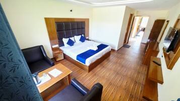 Een hotelkamer met een bed, een bureau, een stoel en een televisie.