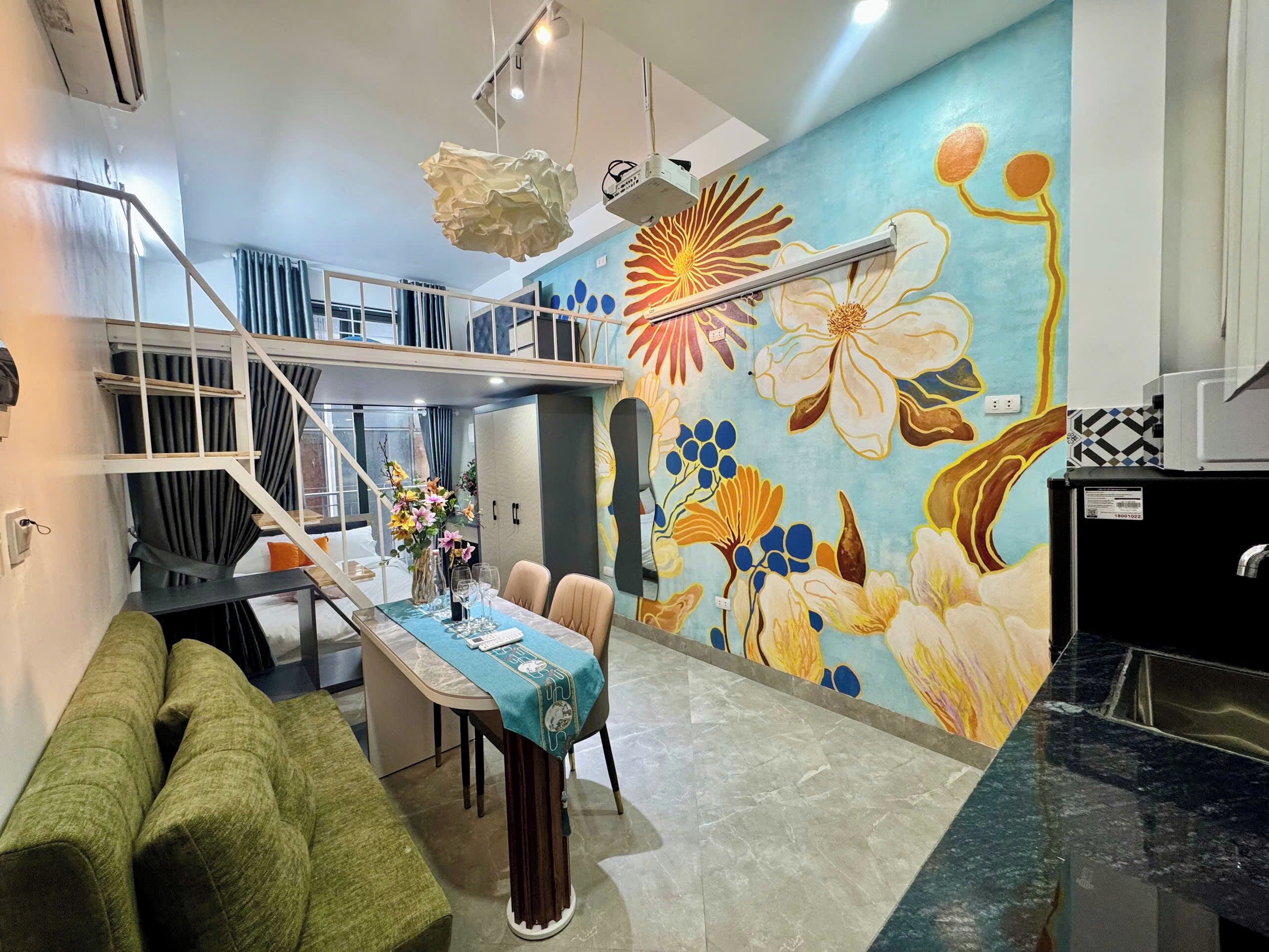 A modern interior with a dining area, a staircase, and a vibrant floral mural.