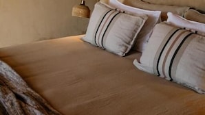 A bed with a headboard, two pillows, and a blanket.