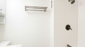 A bathroom with a toilet, a marble sink, a bathtub, and a shower. - Cute Studio in the center of Waikīkī with Parking (Honolulu)