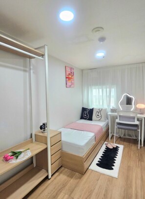 Ein modernes Schlafzimmer mit Bett, Nachttisch, Schreibtisch, Stuhl und Spiegel.