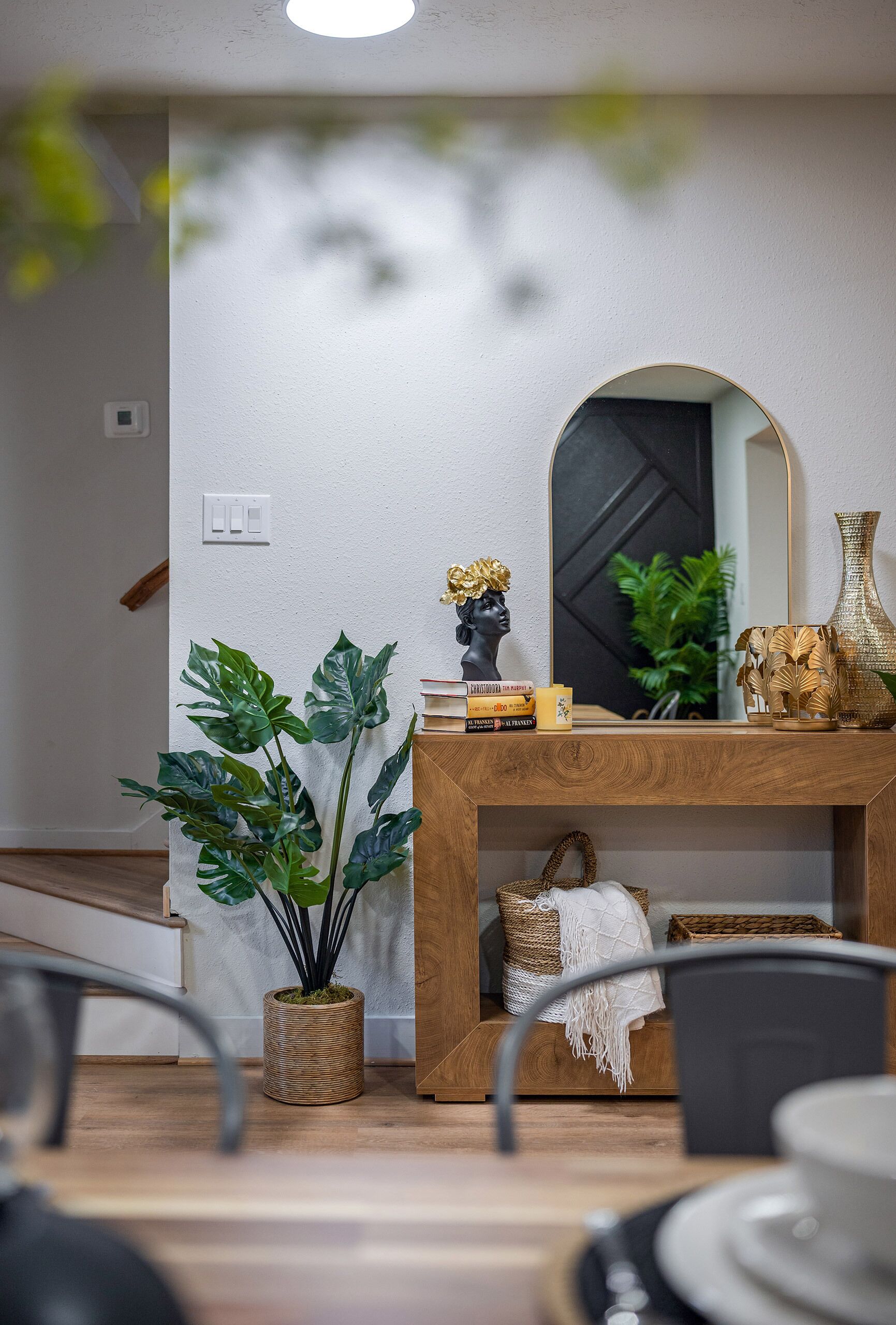Un intérieur moderne agrémenté d’une console en bois, d’un miroir et d’objets décoratifs.