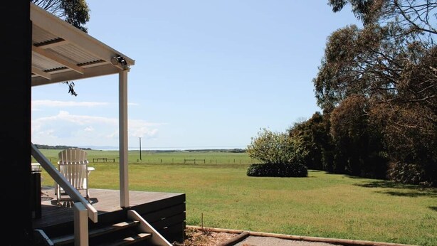 Un espacio al aire libre cubierto con una escalera que lleva a una zona de estar con sillas.