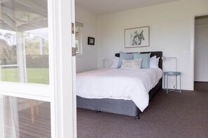 A bedroom with a bed, a bedside table, a window, and a framed picture on the wall. - The Yanakie House - Wilsons Promontory (Yanakie)