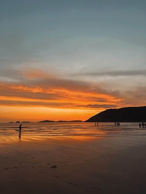 A beach at sunset with people walking on the sand. - The Yanakie House - Wilsons Promontory (Yanakie)