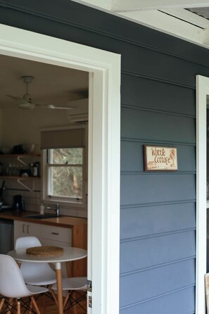 Eine Küche mit weißen Schränken, einem Fenster und einem Schild mit der Aufschrift 'Wattle Cottage'.