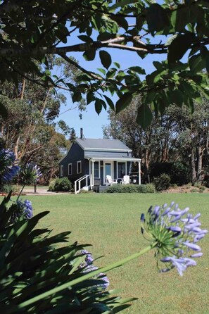 A house with a porch, surrounded by trees and a grassy lawn. - Bluegum - The Yanakie House - Wilsons Promontory (Yanakie)
