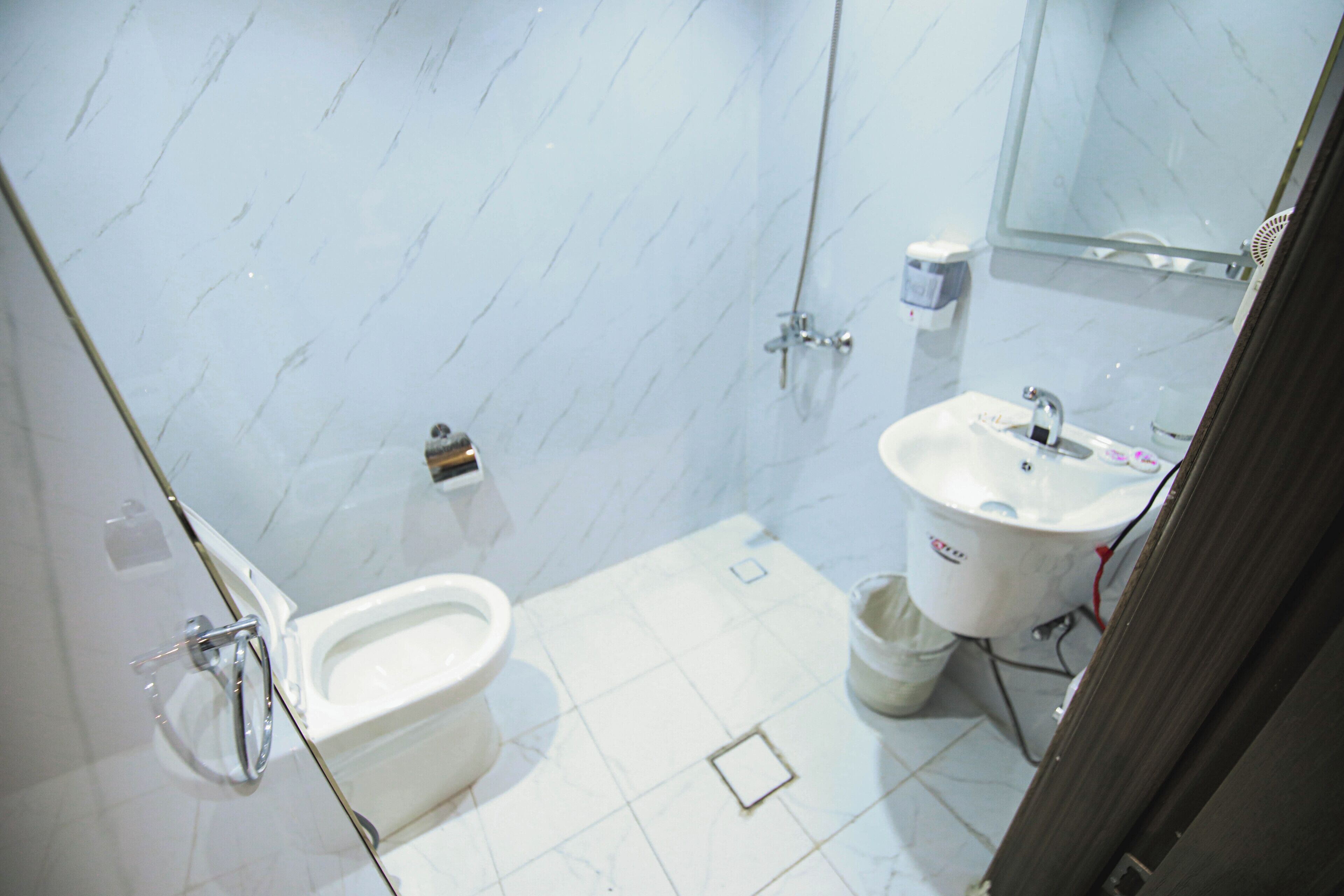 Une salle de bain avec des toilettes, un lavabo et une douche.
