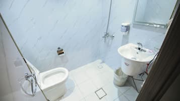 Un baño con inodoro, lavamanos y ducha.